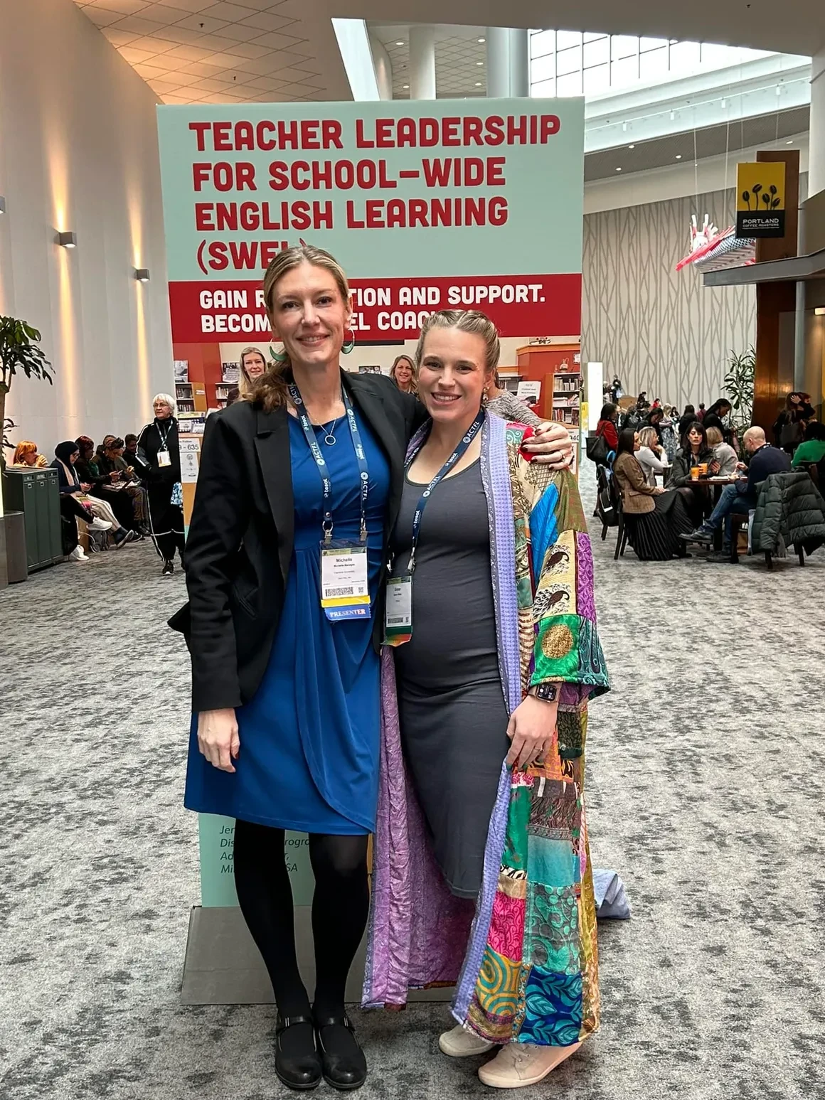 Benegas and TESOL Associate Director of Education Grace Allely posing in front of a Teacher Leadership for School-Wide English Learning banner at the TESOL international convention